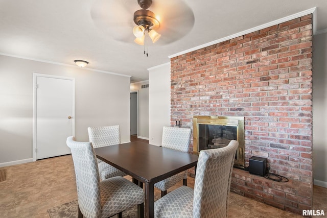 dining area featuring a brick fireplace, crown molding, and ceiling fan