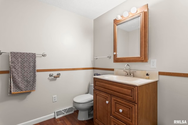 bathroom featuring hardwood / wood-style flooring, vanity, and toilet