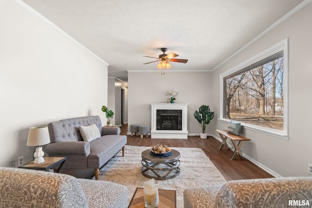 living room featuring dark wood-type flooring, ceiling fan, and crown molding