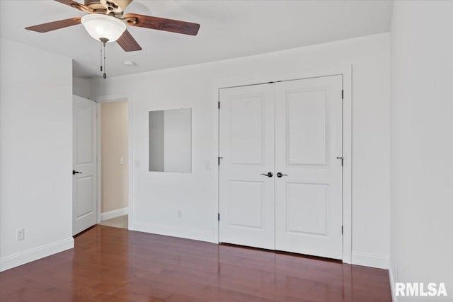 unfurnished bedroom featuring dark wood-type flooring, ceiling fan, and a closet