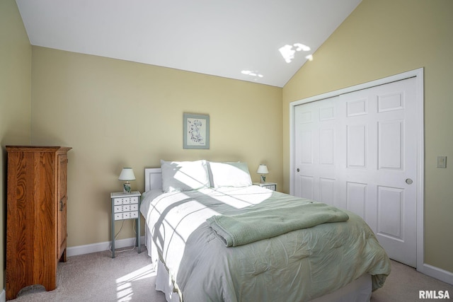 carpeted bedroom featuring vaulted ceiling and a closet