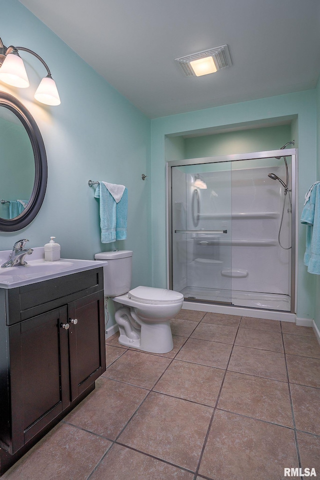 bathroom featuring vanity, toilet, an enclosed shower, and tile patterned flooring