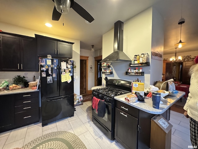 kitchen featuring decorative light fixtures, a kitchen breakfast bar, island exhaust hood, ceiling fan with notable chandelier, and black appliances