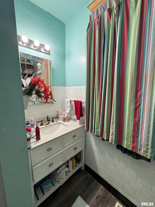 bathroom featuring hardwood / wood-style flooring, vanity, and tile walls