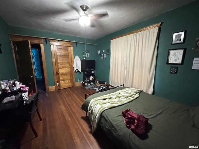 bedroom featuring hardwood / wood-style flooring, ceiling fan, and a textured ceiling