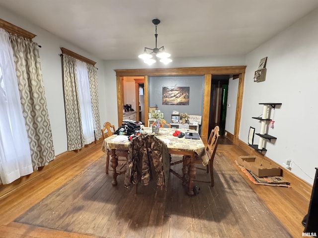 dining space featuring wood-type flooring and a notable chandelier