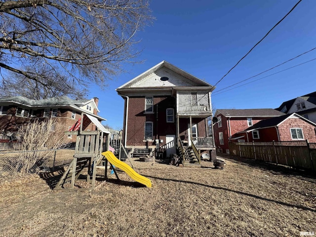 rear view of property featuring a playground