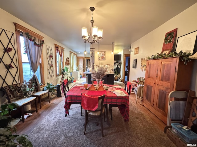 dining space with dark hardwood / wood-style floors and a notable chandelier