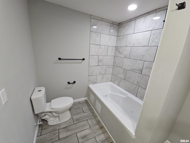 bathroom featuring tiled shower / bath and toilet