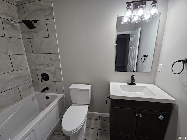 full bathroom with vanity, tiled shower / bath, and toilet