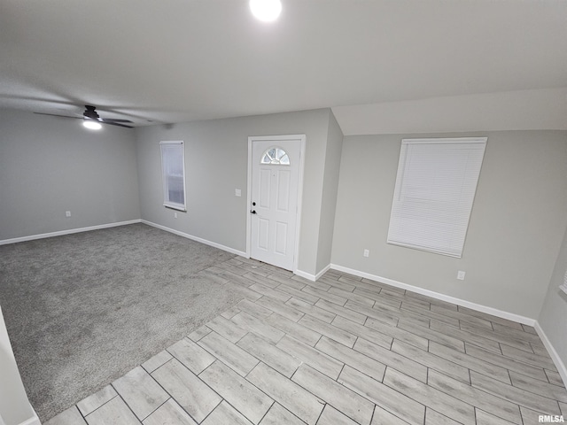 entryway with ceiling fan and light colored carpet