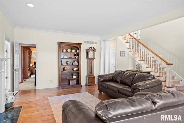 living room featuring decorative columns, ornamental molding, and hardwood / wood-style floors