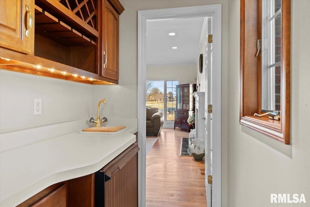 bar with sink and light hardwood / wood-style flooring