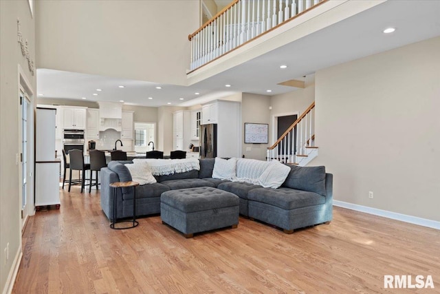 living room featuring light hardwood / wood-style floors and a high ceiling