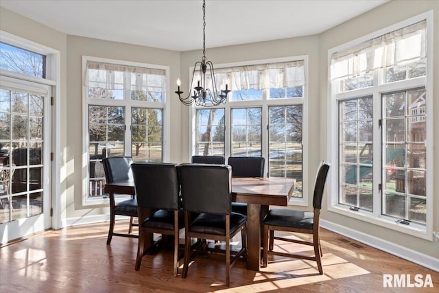 dining room with hardwood / wood-style flooring and a notable chandelier