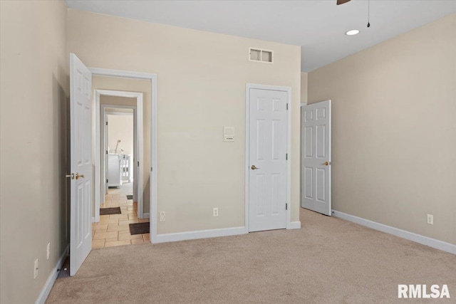 unfurnished bedroom featuring light carpet