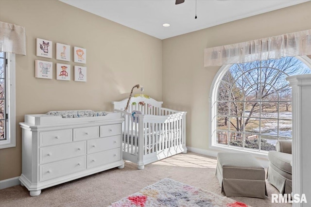 bedroom with a nursery area and light colored carpet