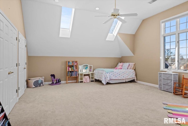 bedroom featuring ceiling fan, light colored carpet, and vaulted ceiling with skylight