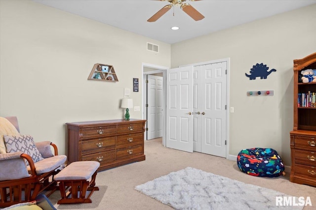 carpeted bedroom featuring ceiling fan and a closet