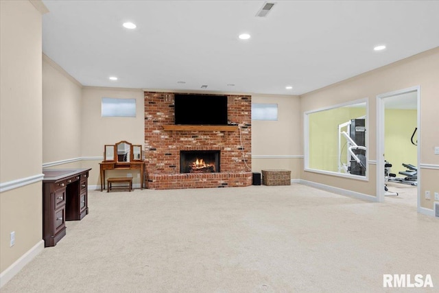 living room with ornamental molding, a brick fireplace, and light carpet