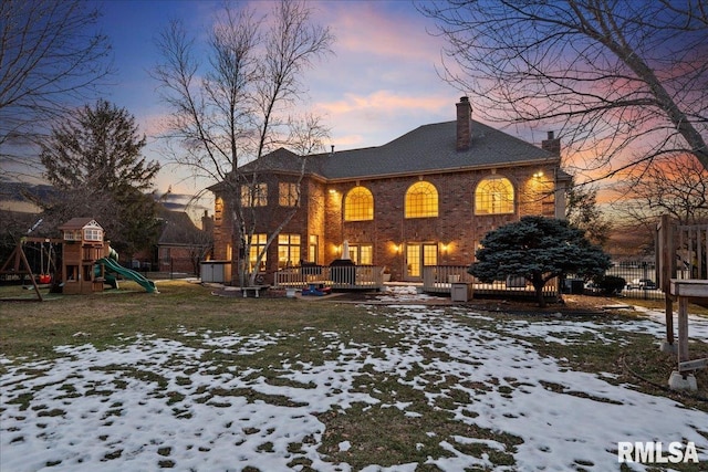 snow covered rear of property featuring a playground