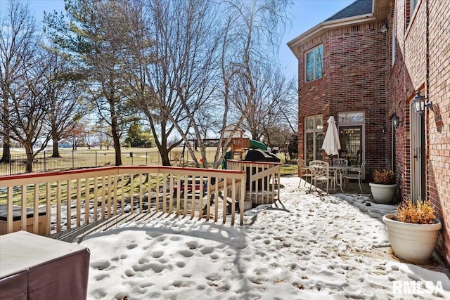 snow covered deck featuring a playground