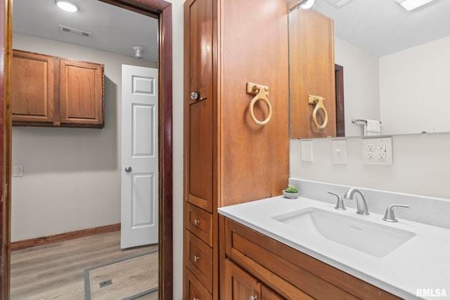 34187 E 6th Rd, Pawnee, IL 62558 - bathroom with baseboards, vanity, wood finished floors, and visible vents