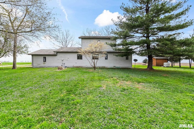 34187 E 6th Rd, Pawnee, IL 62558 - back of property with a lawn, an outbuilding, and a storage shed