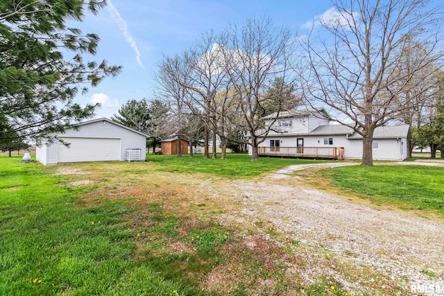 34187 E 6th Rd, Pawnee, IL 62558 - view of yard featuring an outdoor structure, a detached garage, a wooden deck, and a storage shed