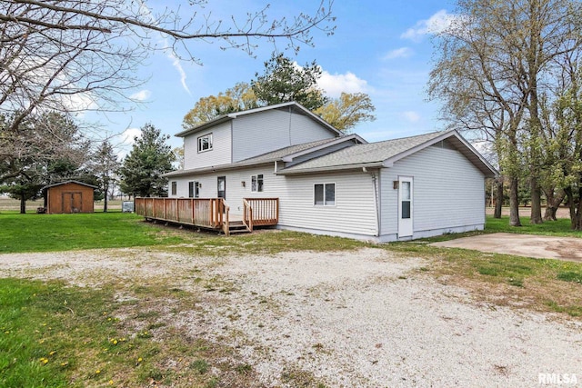 34187 E 6th Rd, Pawnee, IL 62558 - rear view of house featuring a shed, a lawn, an outdoor structure, a wooden deck, and roof with shingles