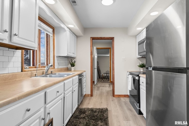 34187 E 6th Rd, Pawnee, IL 62558 - kitchen featuring a sink, stainless steel appliances, light wood-style flooring, white cabinets, and visible vents