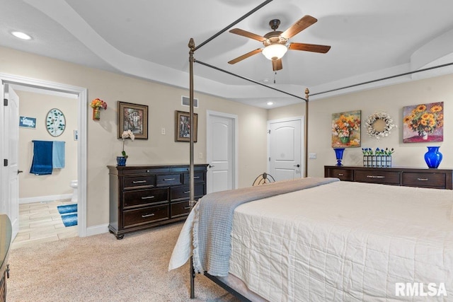 bedroom featuring connected bathroom and light colored carpet