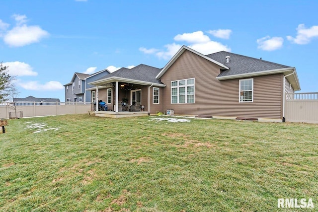 back of property with a yard and a patio area