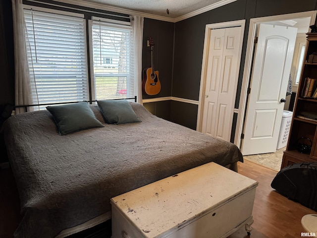 bedroom with crown molding, light hardwood / wood-style floors, and a closet