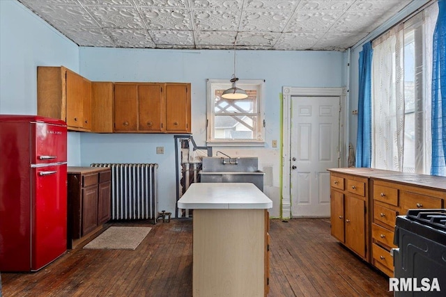 810 E Edwards St, Springfield, IL 62703 - kitchen with radiator, an ornate ceiling, freestanding refrigerator, dark wood-style floors, and brown cabinets