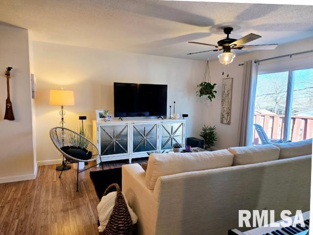 living room with wood-type flooring and ceiling fan