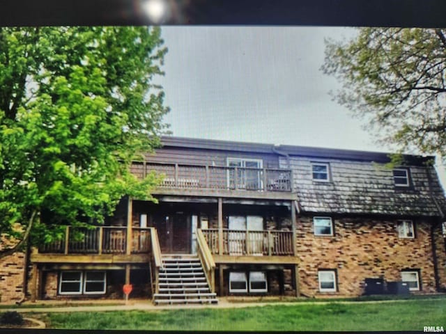 rear view of house with a yard and a deck