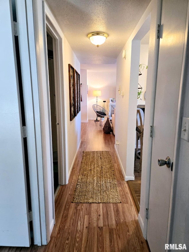 hallway featuring hardwood / wood-style floors and a textured ceiling