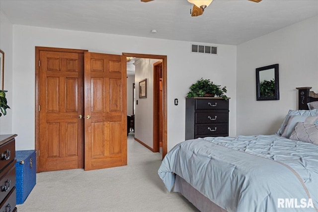 bedroom with visible vents, ceiling fan, and light colored carpet