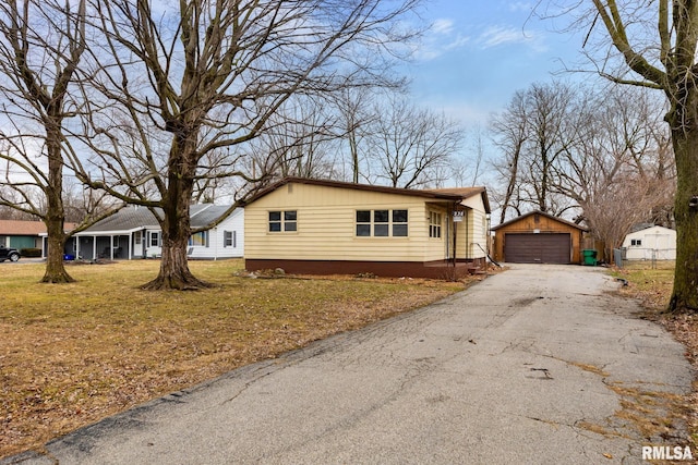 view of front facade with a garage, an outbuilding, and a front yard