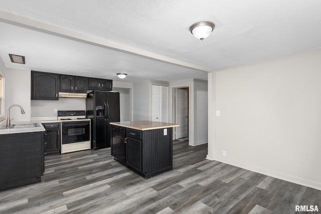 kitchen with dark wood-type flooring, black fridge with ice dispenser, sink, a center island, and white gas range oven