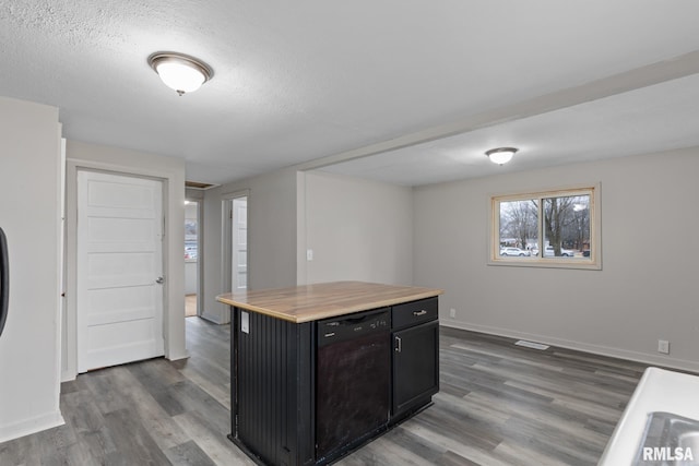 kitchen featuring dark hardwood / wood-style floors, a center island, butcher block counters, and black dishwasher