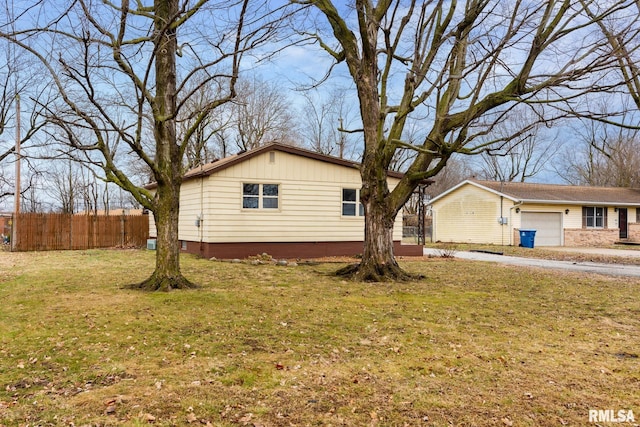 view of side of home featuring a garage and a lawn