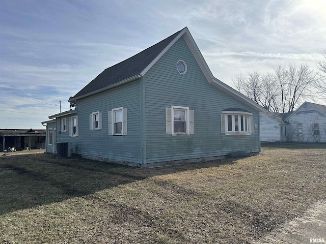 view of side of home with cooling unit and a yard