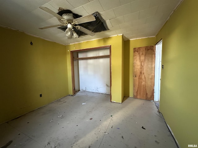 unfurnished bedroom with ceiling fan and a closet