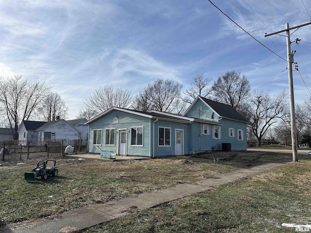 view of front of home featuring central AC and a front yard