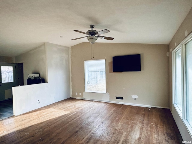 unfurnished room featuring wood-type flooring, vaulted ceiling, and plenty of natural light