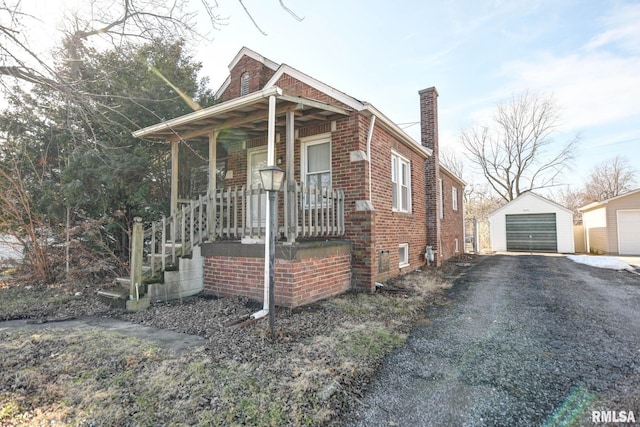 bungalow-style house featuring an outbuilding, a garage, and a porch