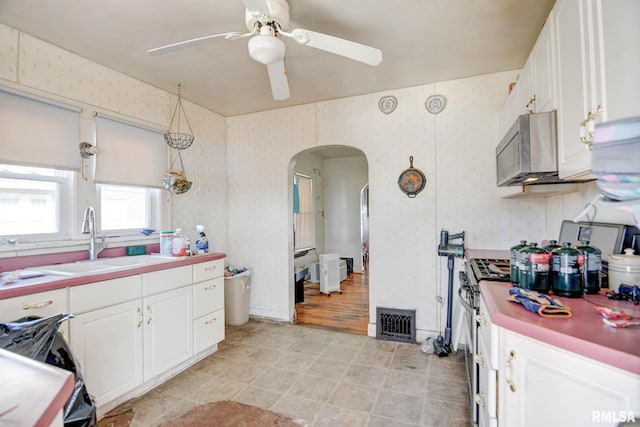 kitchen featuring sink, white cabinetry, appliances with stainless steel finishes, pendant lighting, and ceiling fan