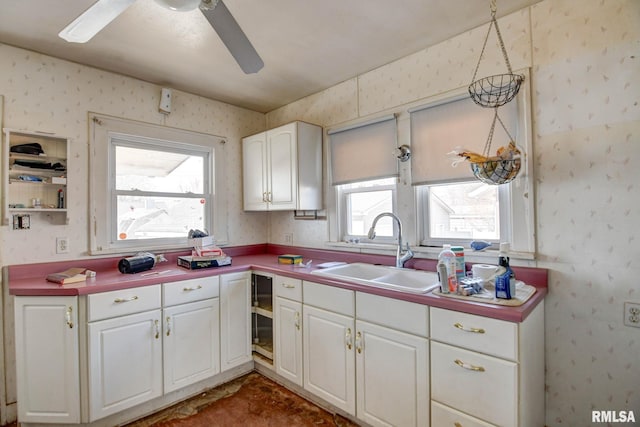 kitchen featuring sink, white cabinets, and ceiling fan